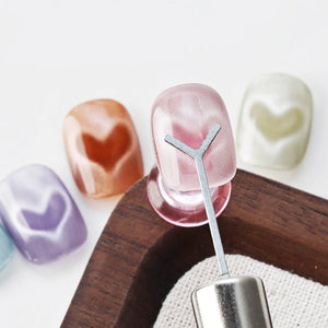 Y-shaped heart magnet tool creating heart patterns on cat eye gel polish pink orange purple blue swatches
