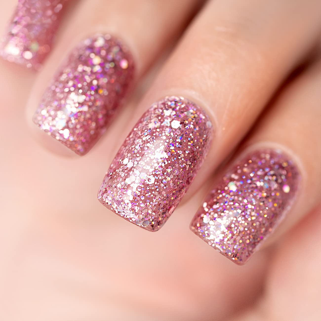 Rose gold glitter manicure with iridescent holographic pink purple silver sparkles on nails
