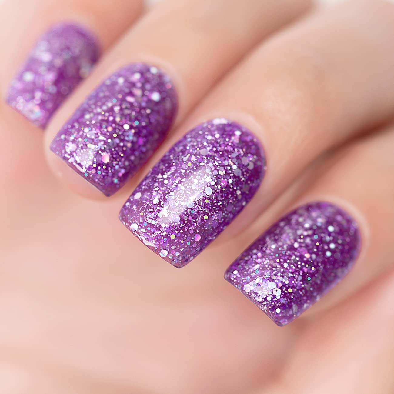 Amethyst purple glitter manicure with iridescent holographic sparkles on nails close-up
